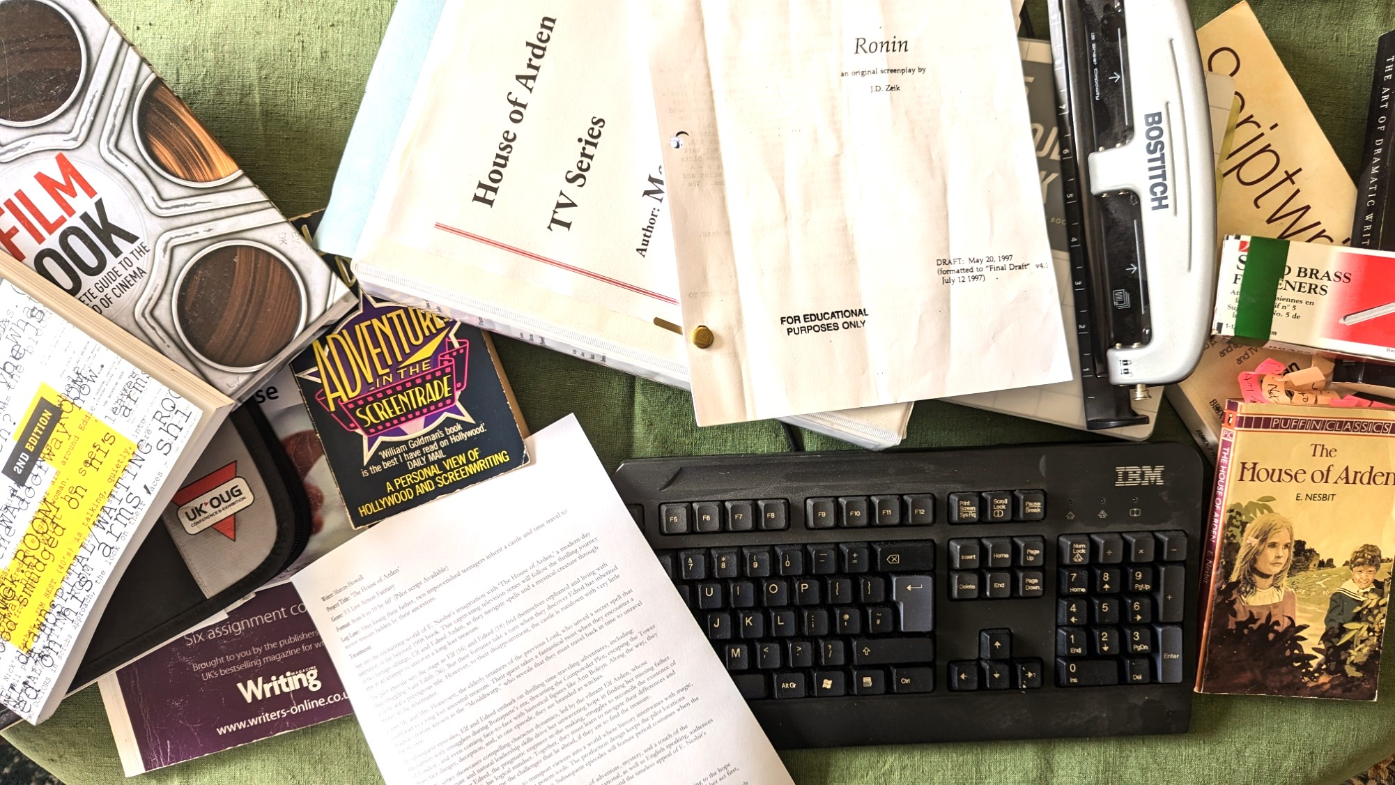 scattered books and scripts for a screenwriter as well as an IBM keyboard